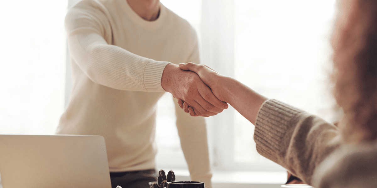 Two people shaking hands after completing negotiations